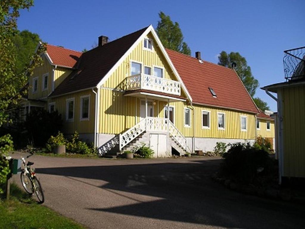 Heimdallhuset في Skånes Värsjö: منزل أصفر مع دراجة متوقفة أمامه