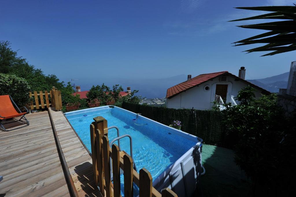 una piscina en un patio trasero con terraza de madera en Villa Walter, en Sorrento