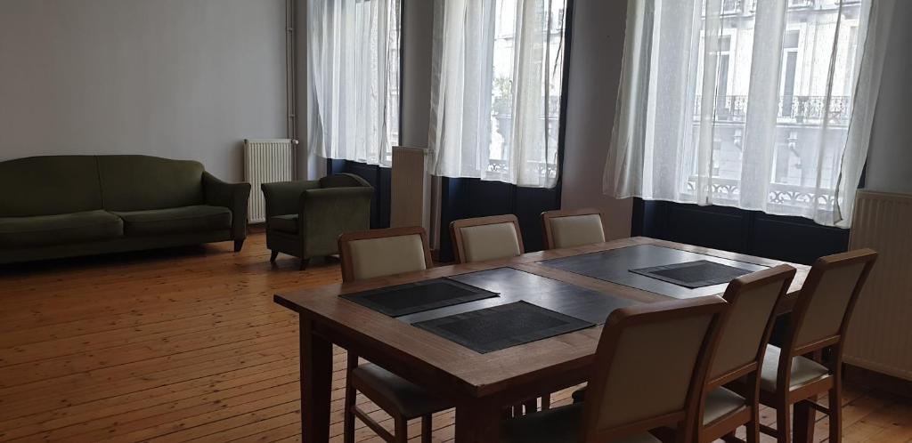 ein Esszimmer mit einem Holztisch und Stühlen in der Unterkunft Appartement LA BOURSE in Brüssel