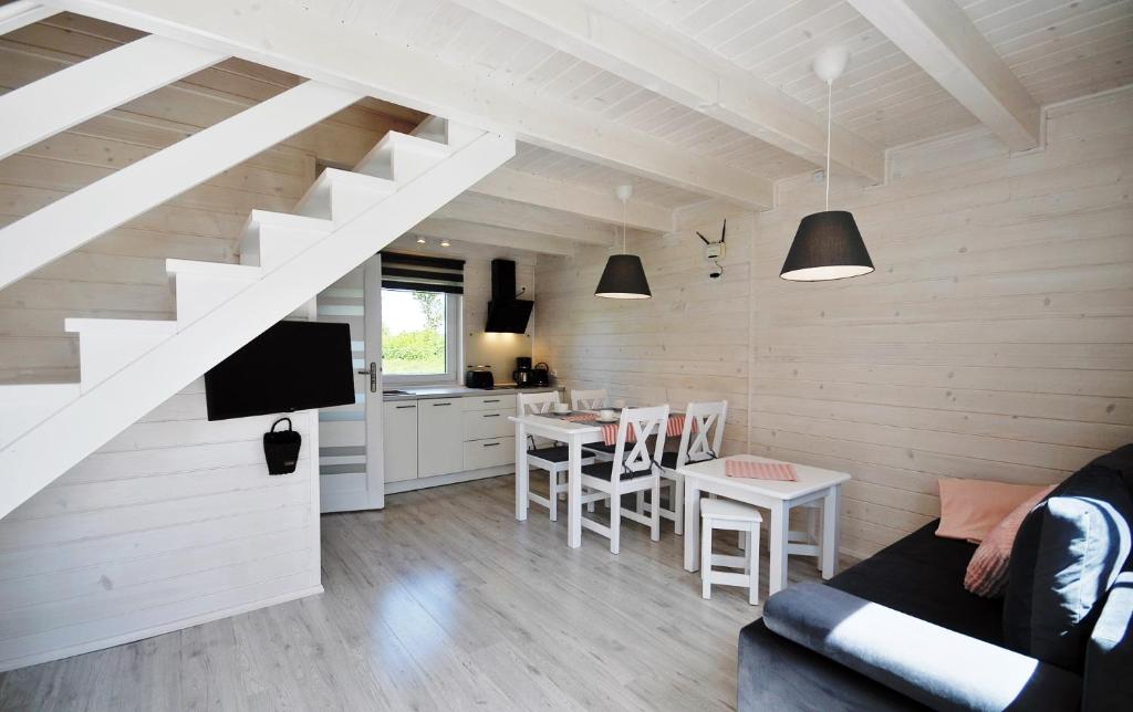 ein Wohnzimmer mit einem Sofa und einem Tisch in der Unterkunft Białe Domki Lux in Grzybowo
