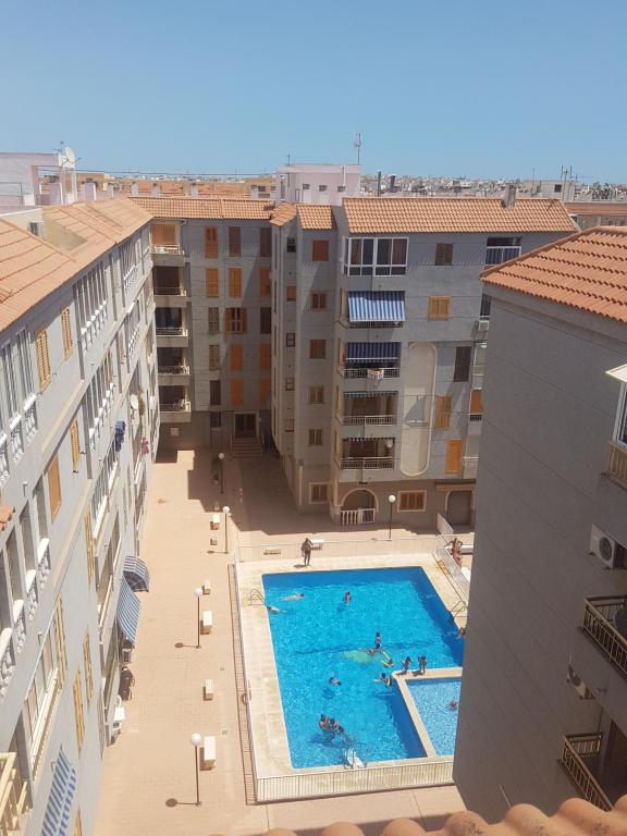 a swimming pool in the middle of some buildings at Apartamento Flamenco in Torrevieja