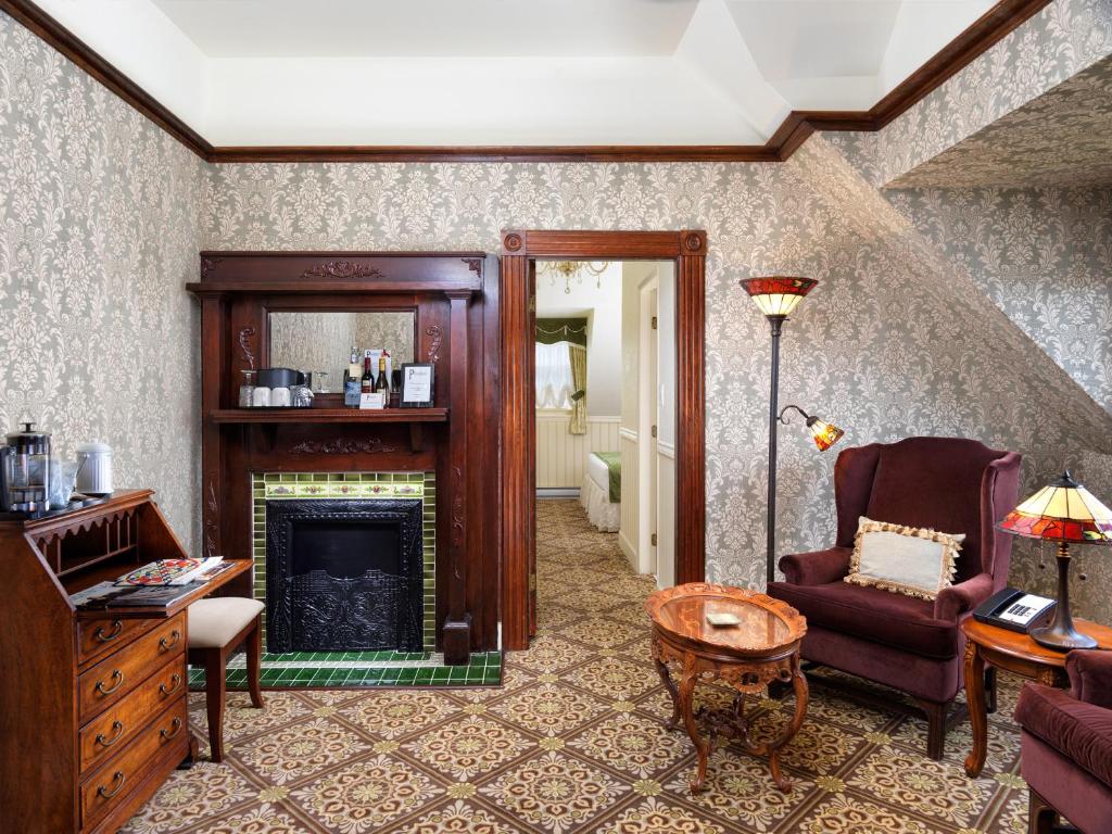 a living room with a fireplace and a chair at Pendray Inn and Tea House in Victoria