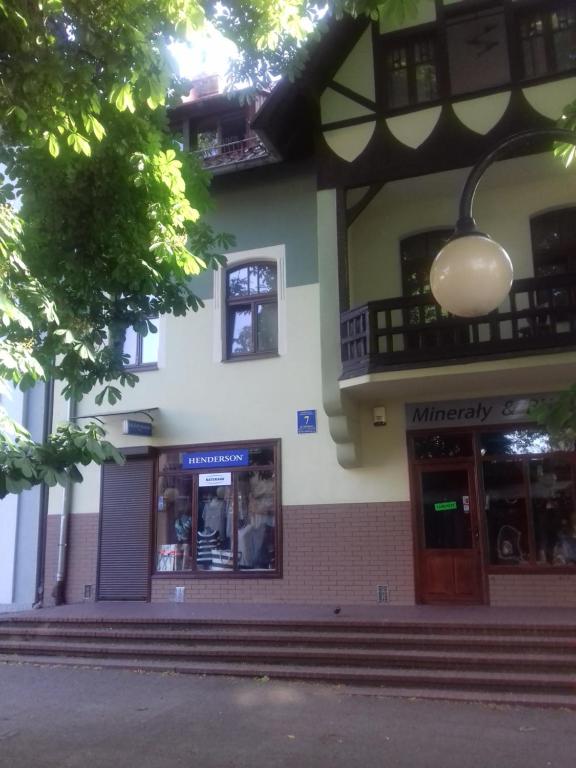 uma loja em frente a um edifício com uma rua em Biały na poddaszu em Polanica-Zdrój