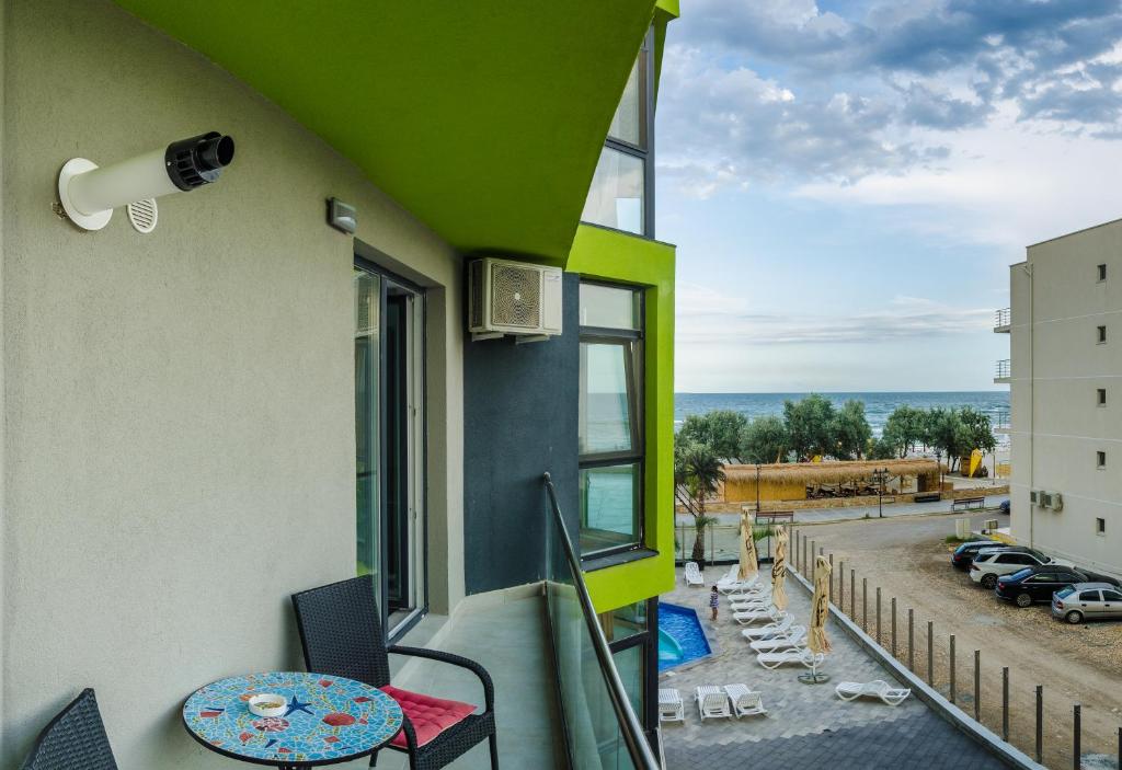 a balcony with a table and chairs and a view of a parking lot at Apartamente Azzurro on the beach in Mamaia Sat/Năvodari