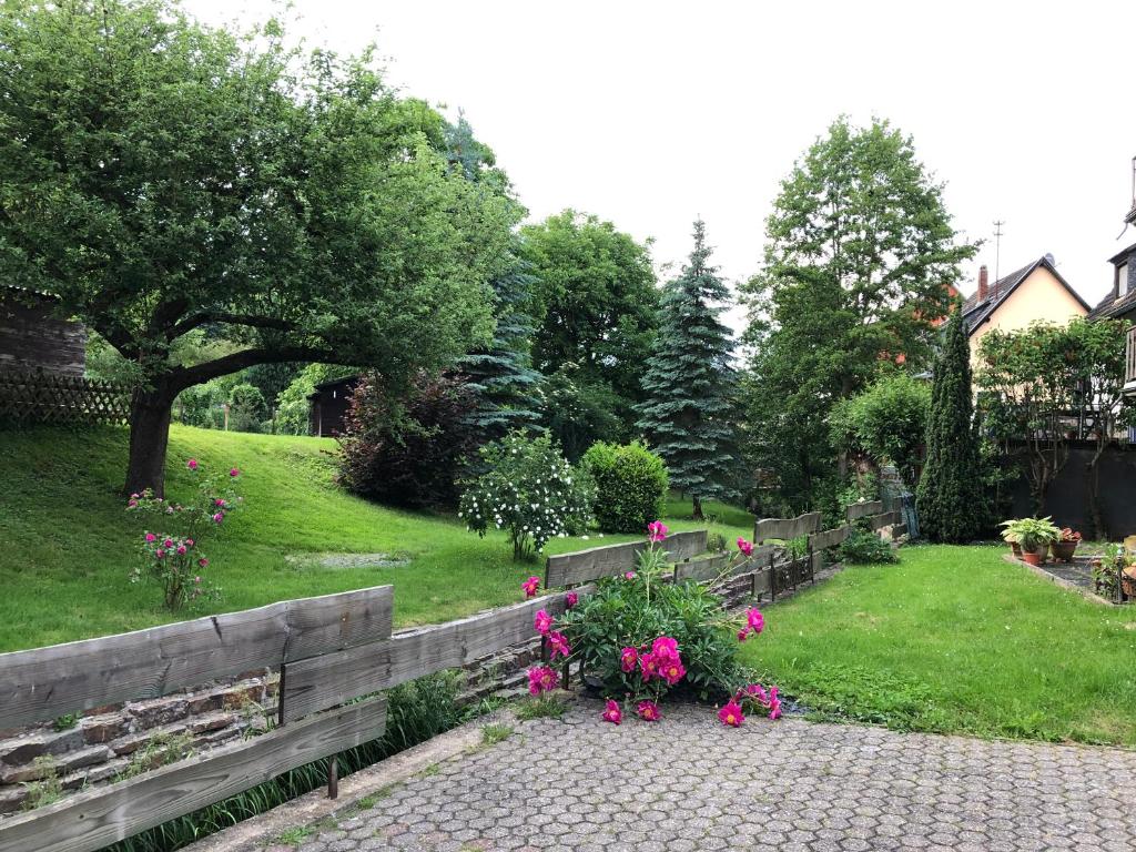 a garden with a wooden fence and pink flowers at Gästehaus La Madonnina in Bad Breisig