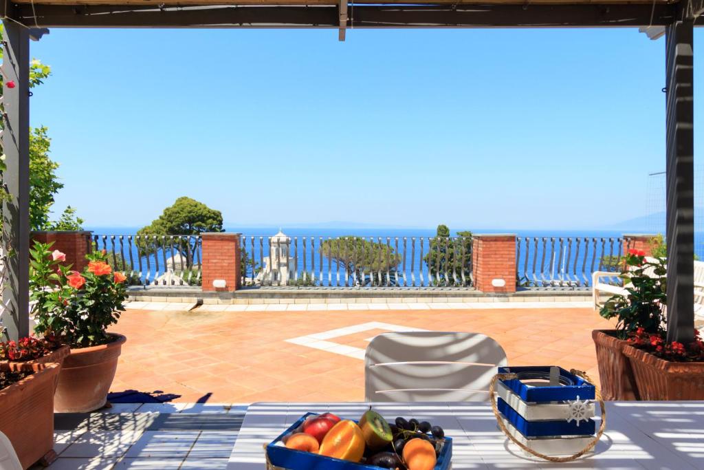 einen Tisch mit einem Tablett mit Obst und Gemüse auf einer Terrasse in der Unterkunft AQUAMARINE Relaxing Capri Suites in Capri