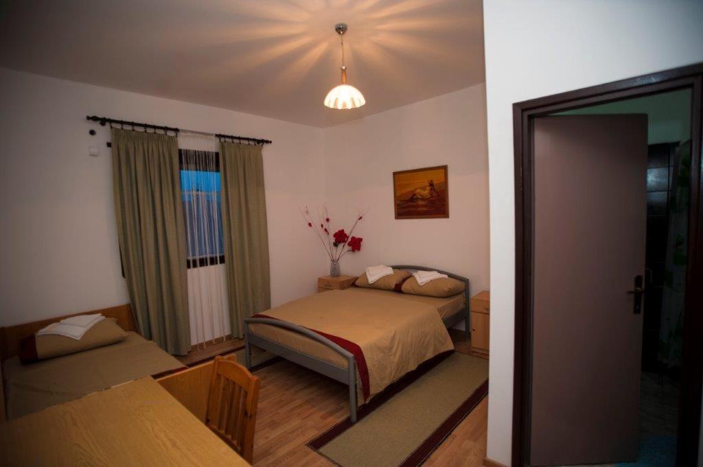 a bedroom with a bed and a window at Vinarija Andjusic in Dračevo