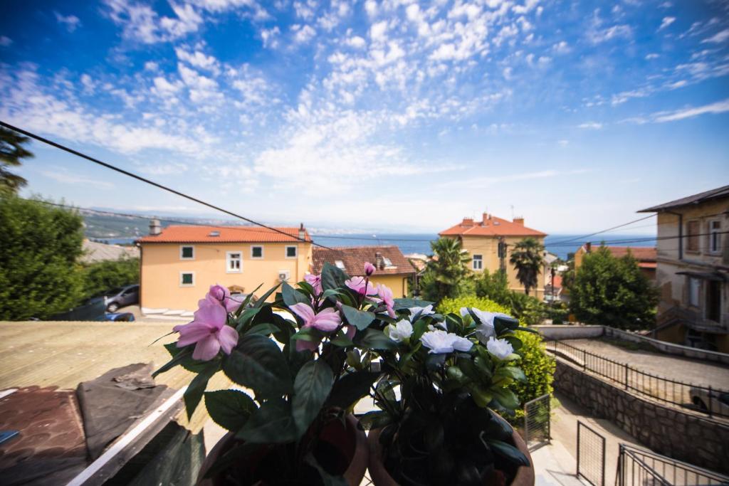 a vase filled with flowers sitting on a balcony at Apartments Patricija in Opatija