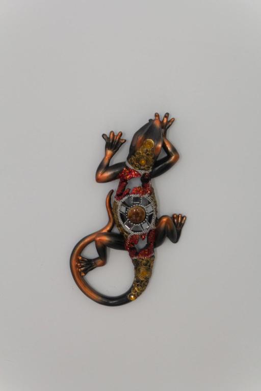 a lizard decoration hanging on a white wall at Apartamento Barbancho in Cáceres
