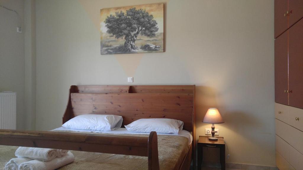 a bedroom with a bed with a tree on the wall at Avantis Apartments in Perivólia