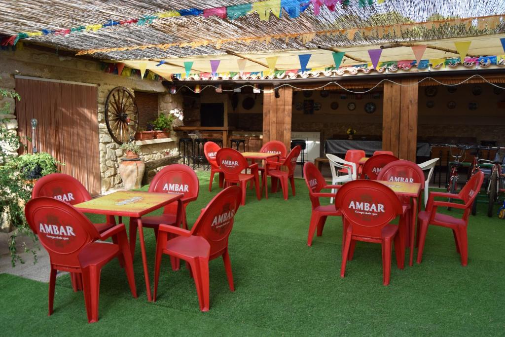 un grupo de sillas y mesas rojas en un restaurante en Casa Rural Javier, en Valmuel