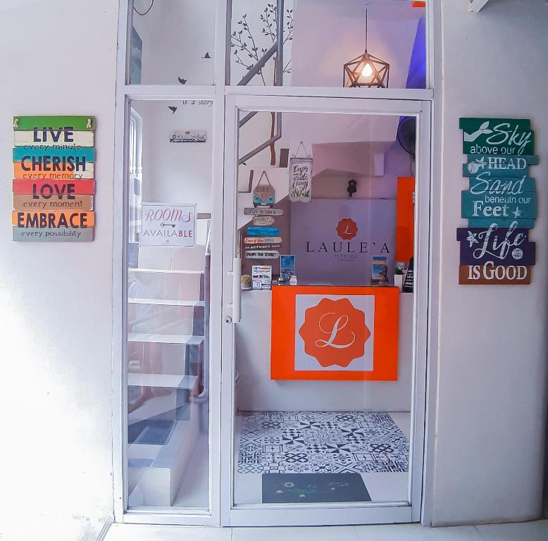 a door to a shop with a sign in it at Laule'a Hostel in El Nido