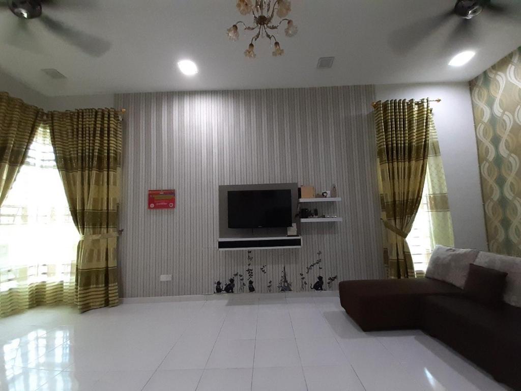 a living room with a couch and a flat screen tv at Selesa Indah Guest House Melaka - Near City Centre in Melaka