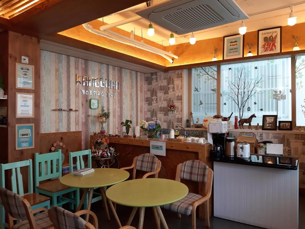 ein Restaurant mit zwei Tischen und Stühlen und einer Theke in der Unterkunft Kangguan Guesthouse in Tongyeong