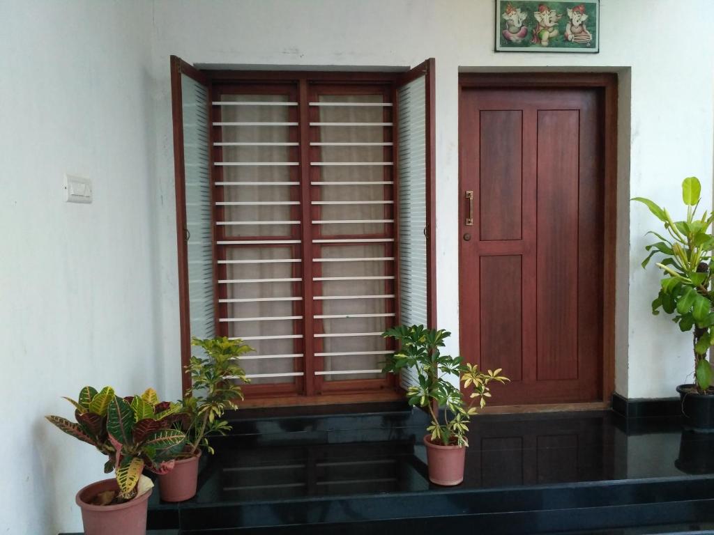 a door with potted plants in front of a house at Yaa Residency near VIT in Vellore