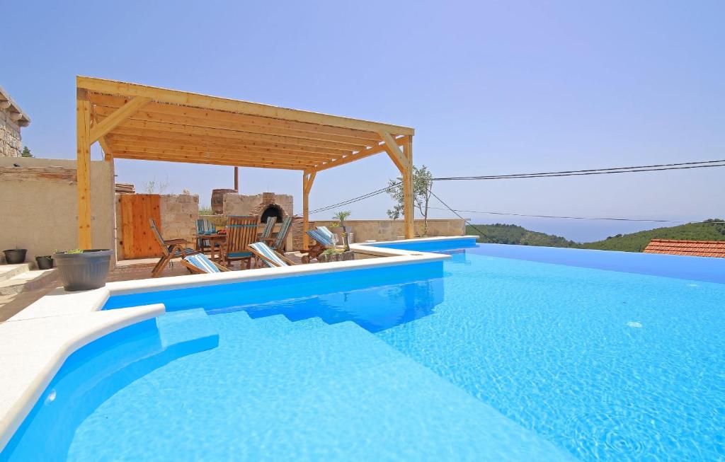 a blue swimming pool with a pergola on a house at Villa Sea star in Babino Polje