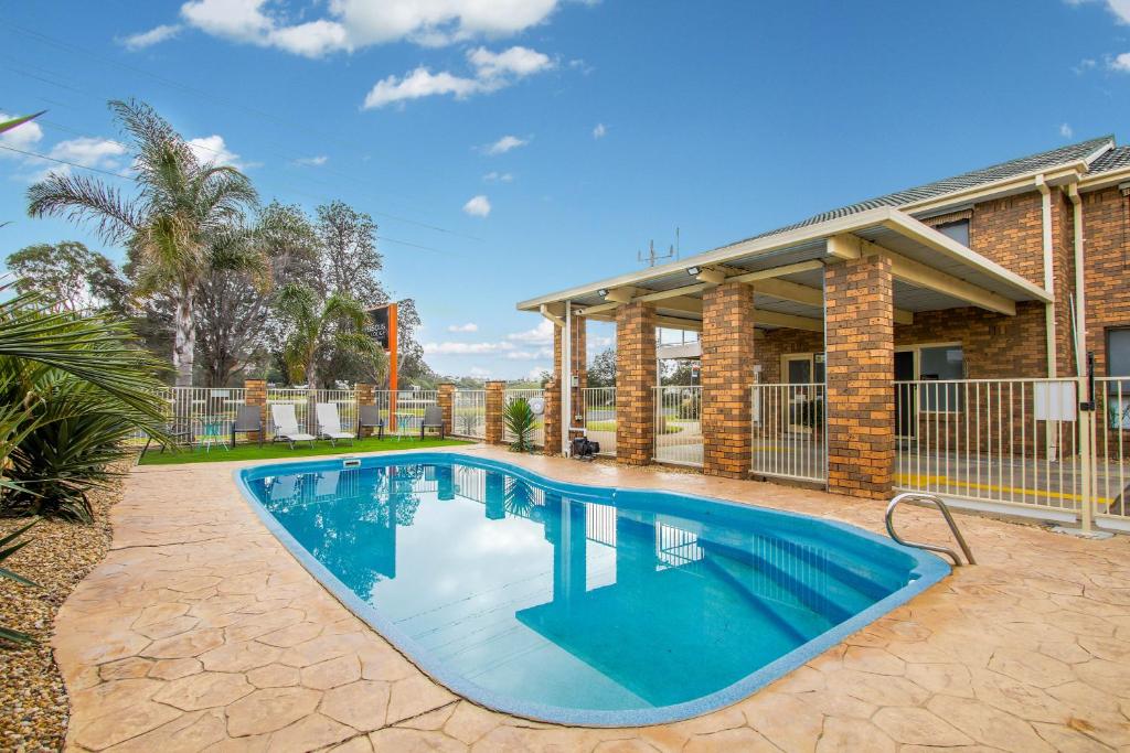 a swimming pool in front of a house at Hybiscus Waterfront Apartments in Lakes Entrance