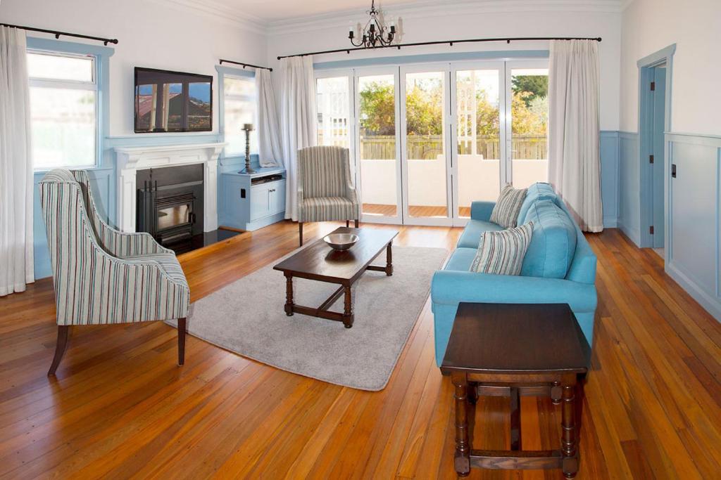 a living room with a blue couch and a fireplace at McDougall Cottage in Wanaka