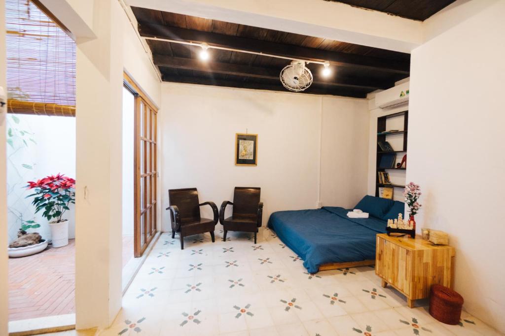 a bedroom with a bed and a table and chairs at a-mâze house in Hue