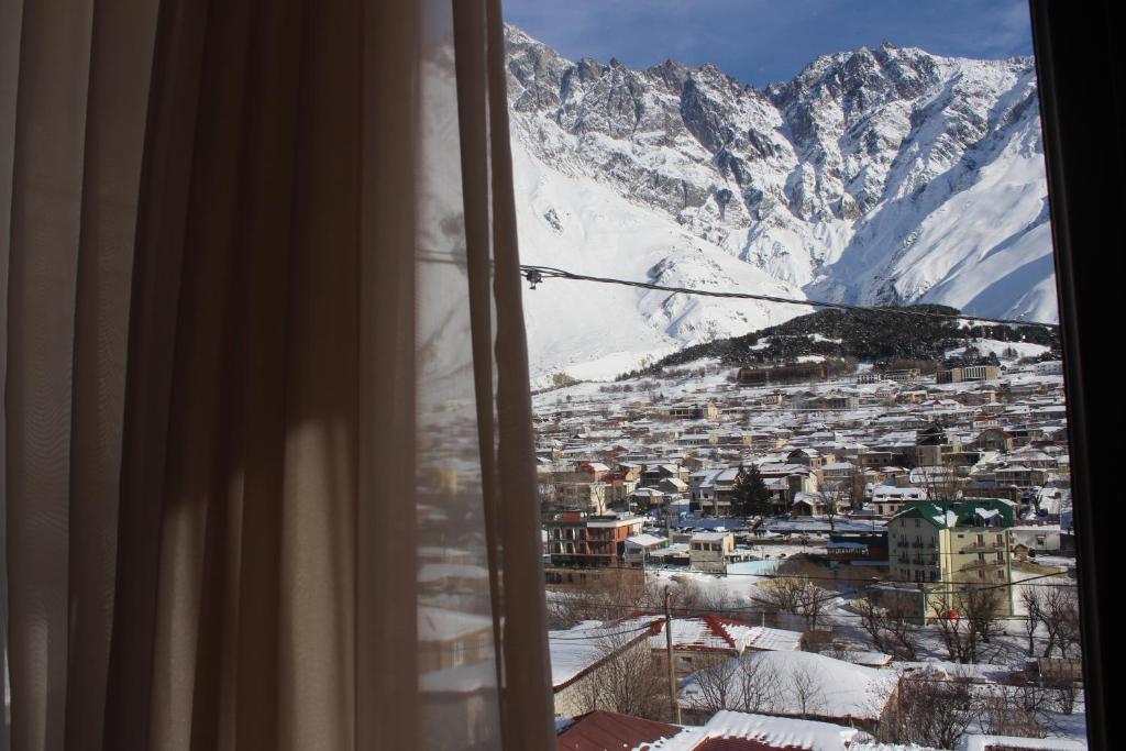 una ventana con vistas a una montaña nevada en Ketino's Home en Kazbegi