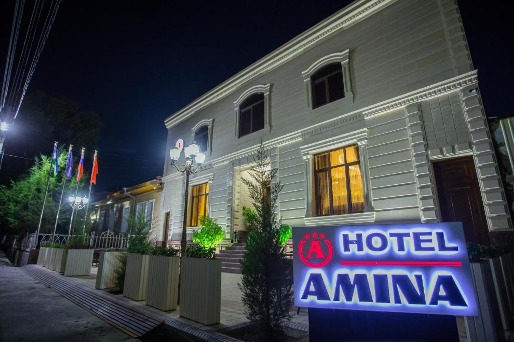 un cartel de hotel amina frente a un edificio en Amina hotel en Samarcanda