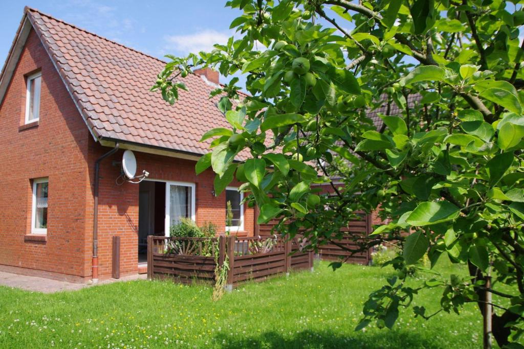 a red brick house with a wooden fence in the yard at Luettje-Glueck-2 in Pogum