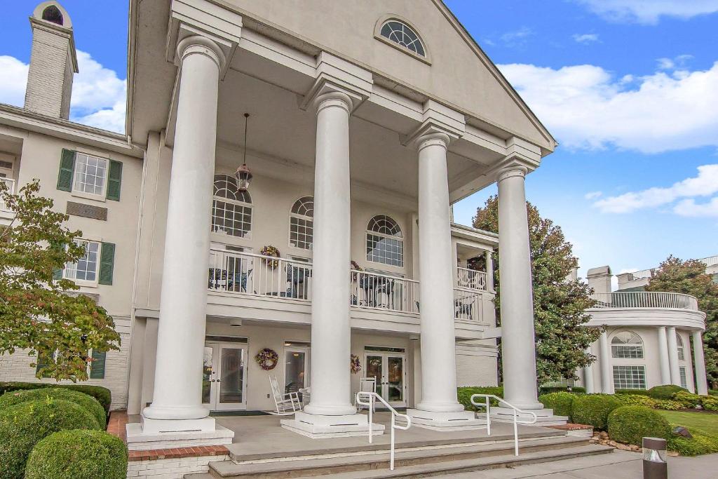 a large white building with columns at Clarion Inn Willow River in Sevierville