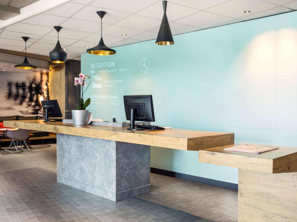 a lobby with a desk with a computer on it at ibis Saint-Denis Stade Ouest in Saint-Denis