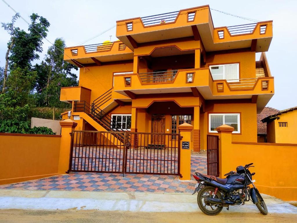 a motorcycle parked in front of a yellow house at Lakshmi Nilaya Family Homestay on Hilltop-360 Degree View in Madikeri