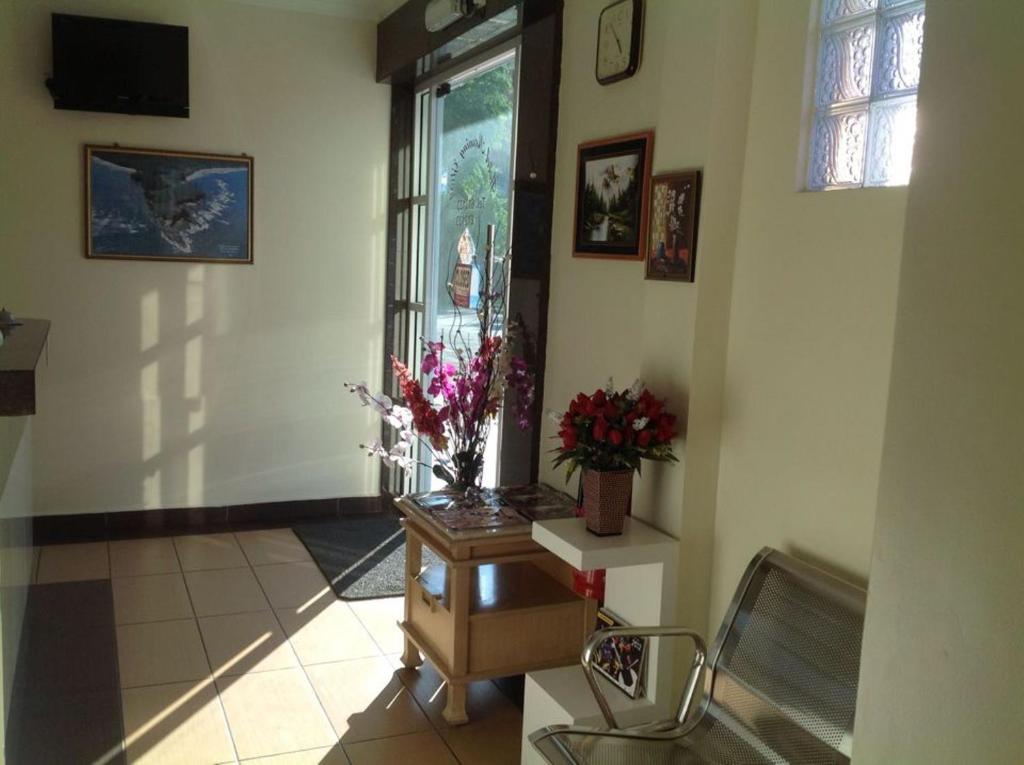 um corredor com um vaso de flores sobre uma mesa em Hotel Morning Glory em Kudat