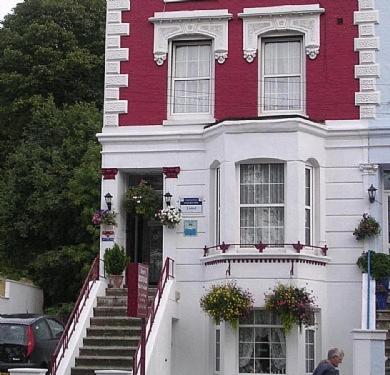 a red and white house with stairs and a man walking past it at Dover's Restover Bed & Breakfast in Dover