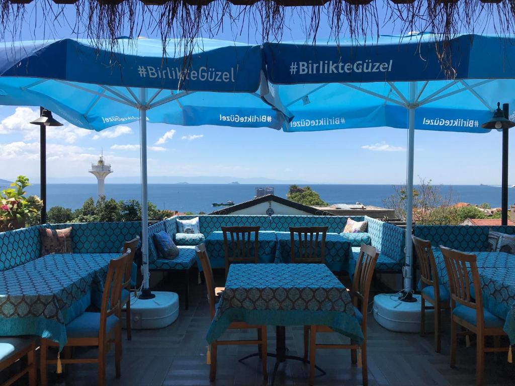 a restaurant with blue tables and chairs and umbrellas at Sphendon Hotel in Istanbul