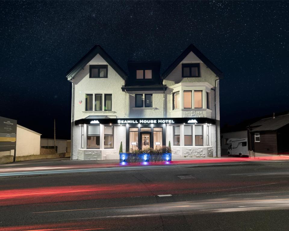 a white building on a street at night at Seamill House Hotel in Seamill