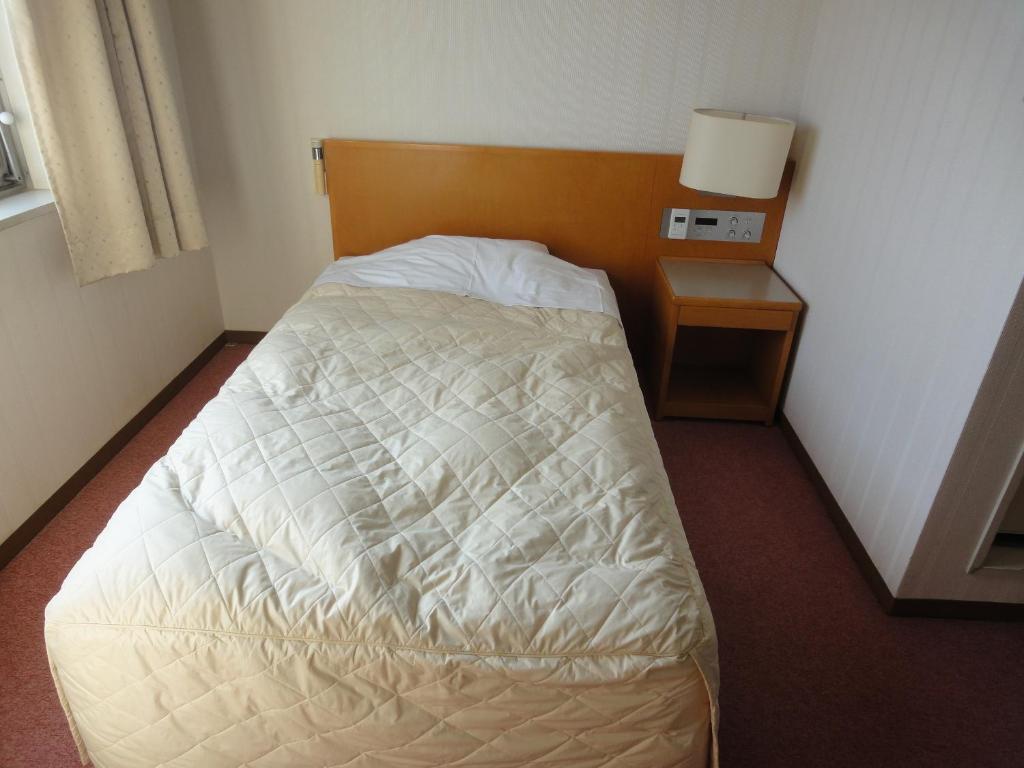 Postel nebo postele na pokoji v ubytování Hiroshima International Youth House JMS Aster Plaza