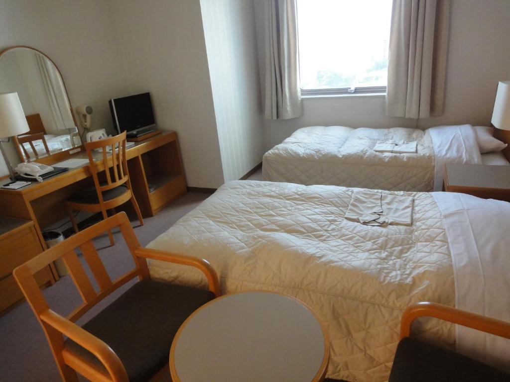 Postel nebo postele na pokoji v ubytování Hiroshima International Youth House JMS Aster Plaza