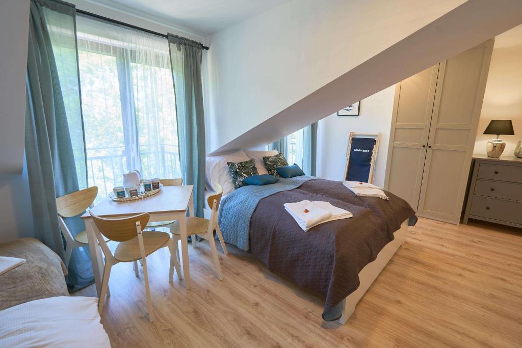 a bedroom with a bed and a table and a window at Villa Ventus in Rewal
