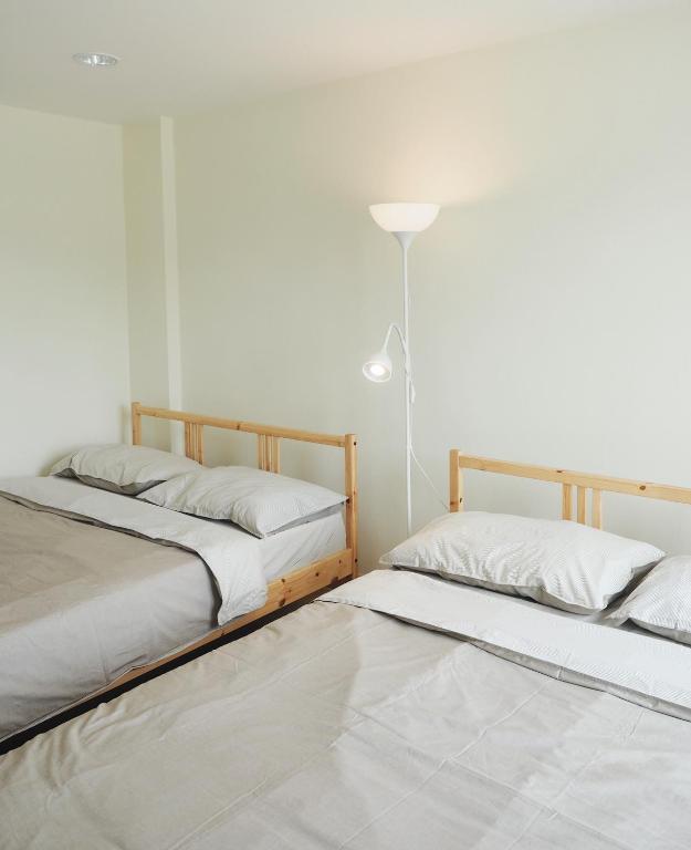two beds sitting next to each other in a room at Hostbox Bangkok in Lat Krabang