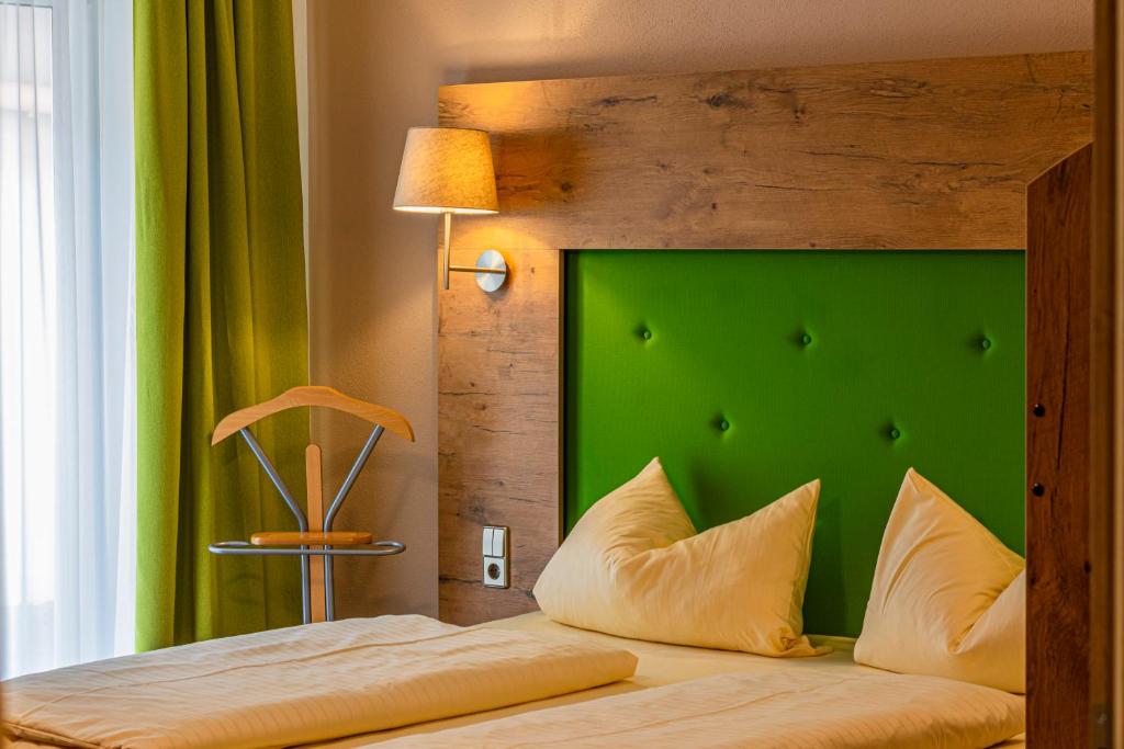 a bed with a green headboard in a room at Günzburg City in Günzburg