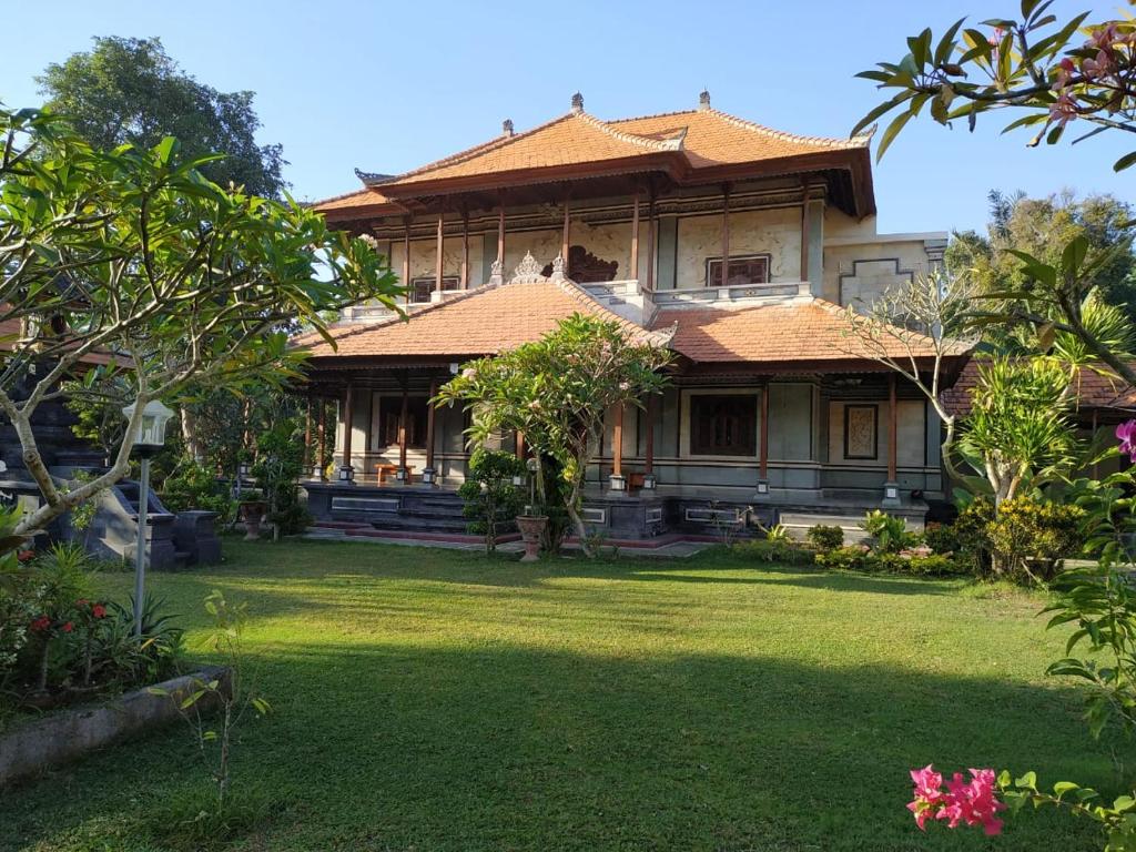 an old house with a grass yard in front of it at Taman Sari Tagtag in Sanur