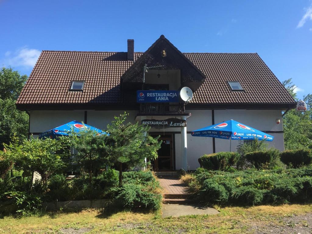 budynek z dwoma parasolami przed nim w obiekcie Restauracja Łania w Koszalinie