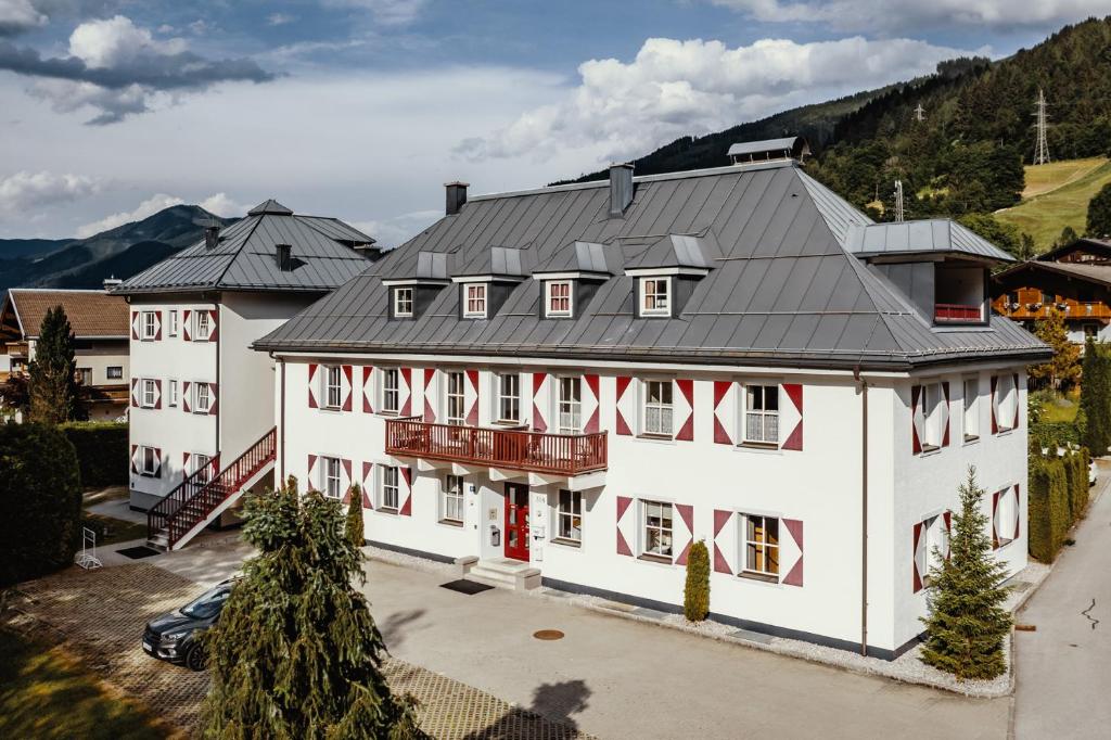 a large white building with a black roof at Kitz Residenz by Alpin Rentals - 8 Apartments in Kaprun