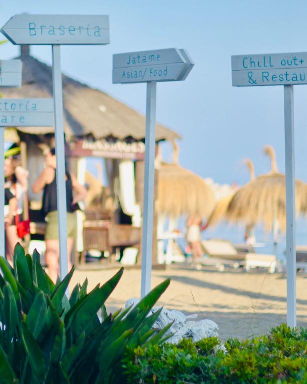 a beach with umbrellas and people on the beach at Gran Hotel Guadalpín Banus in Marbella