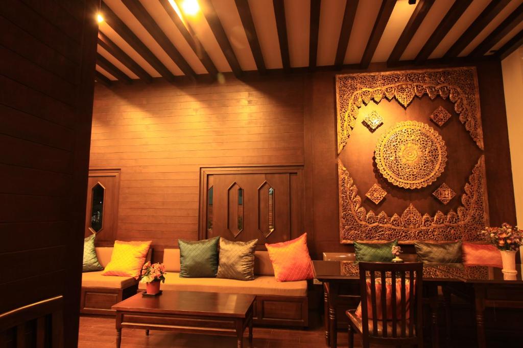 a living room with a couch and a painting on the wall at Baan Ratchiangsaen in Chiang Mai