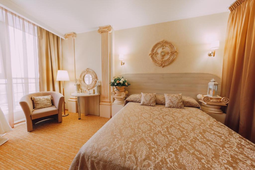 a bedroom with a large bed and a chair at Olymp Kazan in Kazan