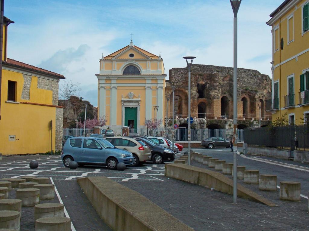 un gruppo di auto parcheggiate in un parcheggio di fronte a un edificio di Janara - Teatro Romano a Benevento
