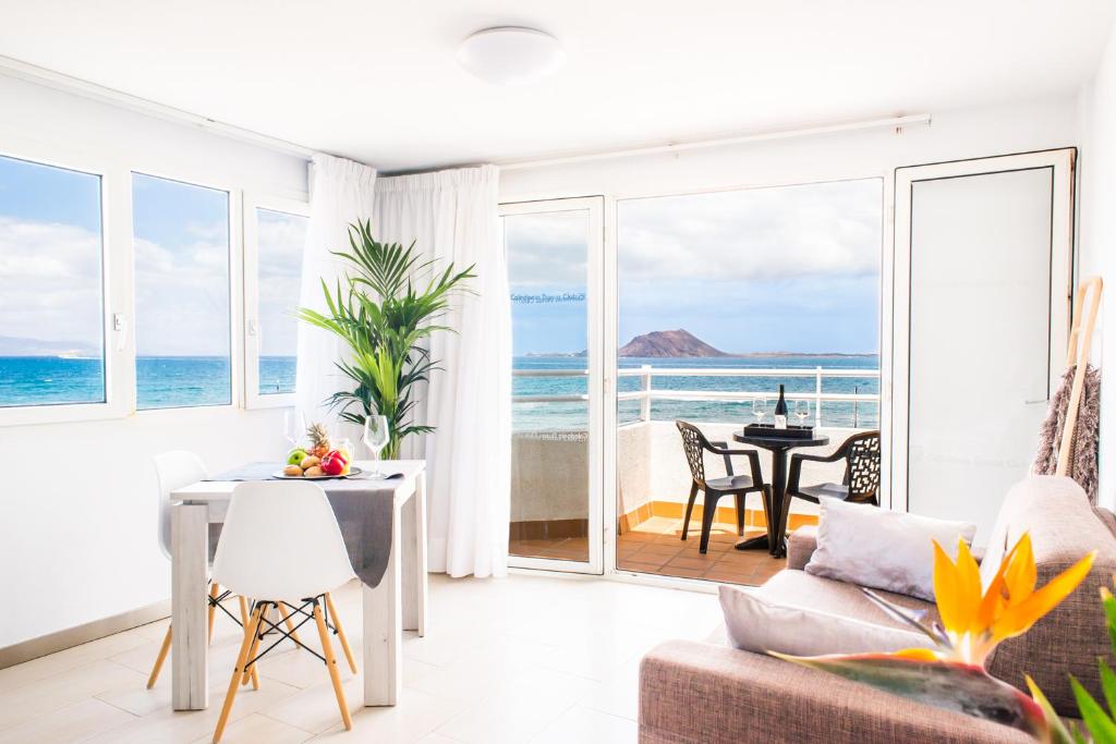 een woonkamer met uitzicht op de oceaan bij Dunas Club - Hotel & Apartamentos in Corralejo