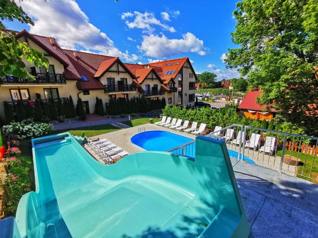 a swimming pool in front of a house at Hotel Santa Monica in Mikołajki
