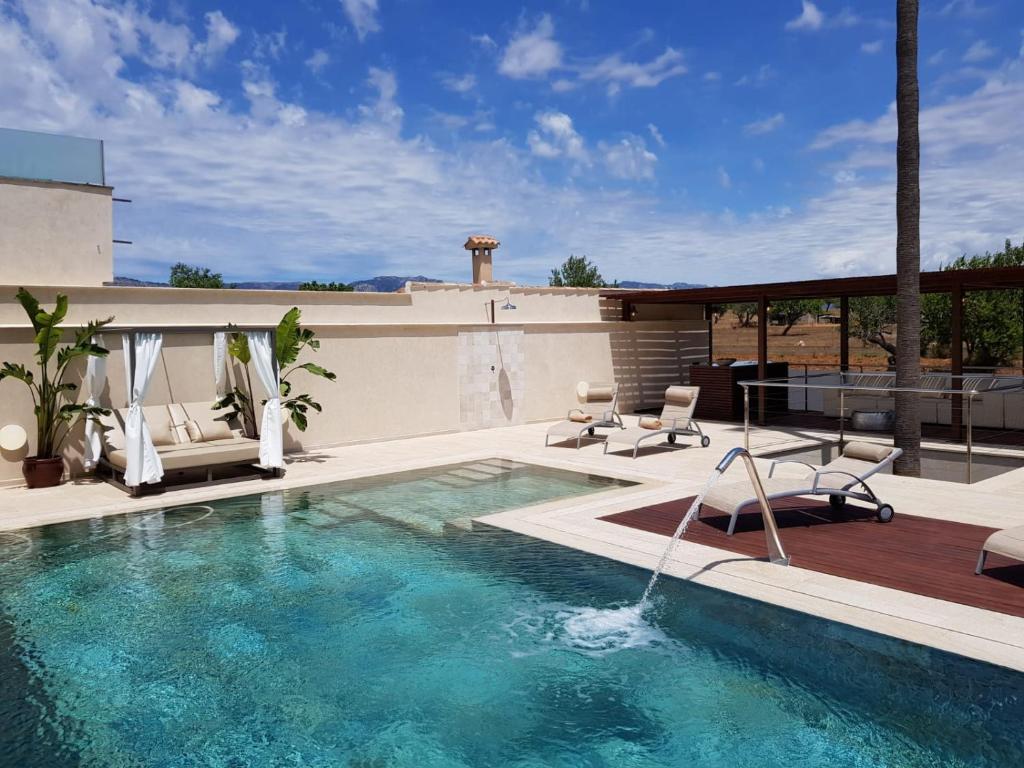 a swimming pool with two chairs and a patio at Villa Rainbow Home Mallorca in Palma de Mallorca