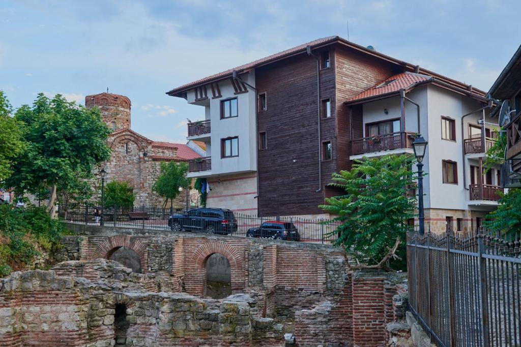 un antiguo edificio de ladrillo con un coche aparcado delante en Hotel Saint John Baptist Nessebar en Nesebar