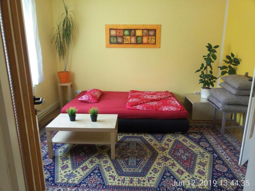 a bedroom with a red bed and a table at Garden Apartment Donau-City (P&R) in Vienna